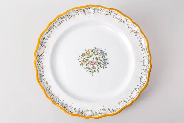 Assiette plate Louis XV avec décor au bouquet polychrome et frise