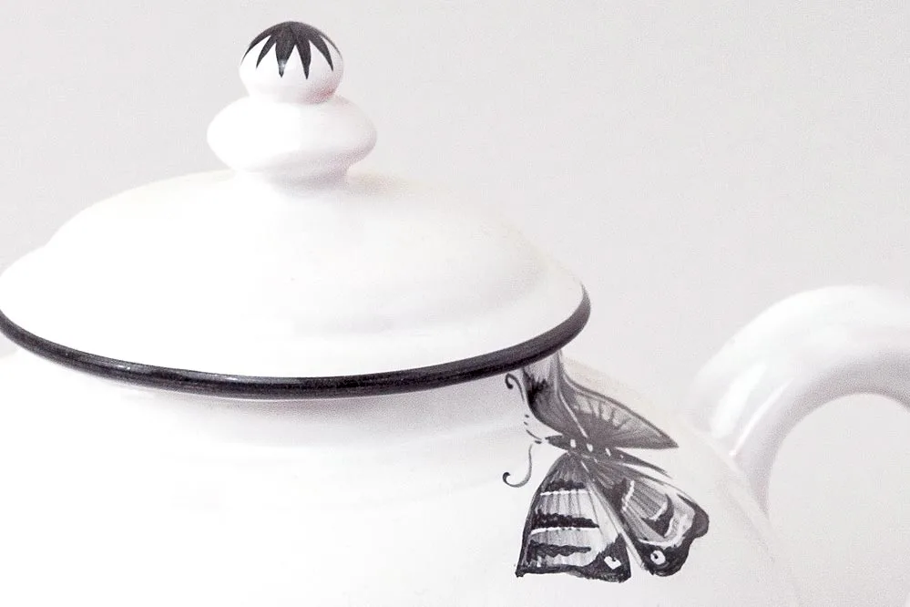 Detail of round teapot with black butterflies motif
